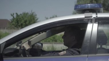 İki polis memuru şehrin etrafında bir arabada devriye geziyor.