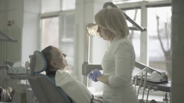 女牙医与病人沟通 — 图库视频影像