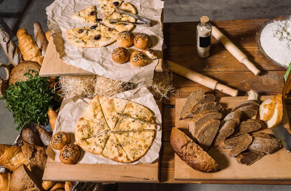 Tavolo in legno con diversi tipi di pane. Vista dall'alto . — Foto Stock