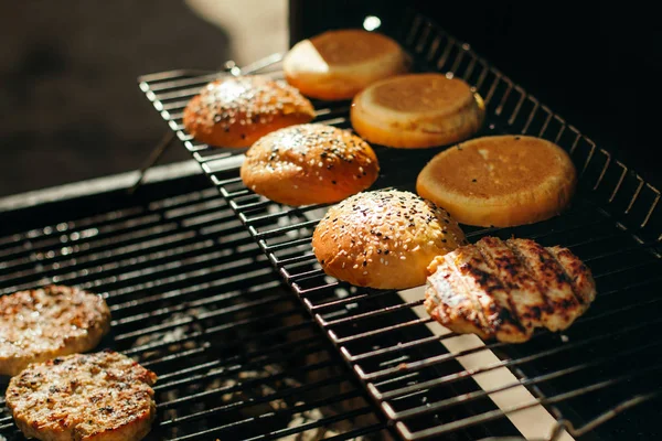 Housky na hamburgery se sezamem, grilované karbanátky. — Stock fotografie