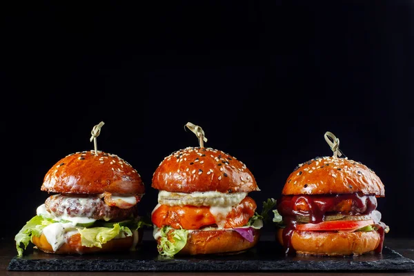 Pon hamburguesas con carne. Sobre un fondo negro-2 — Foto de Stock