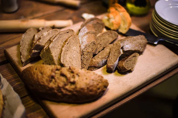 Pane nero affettato sulla vecchia tavola di legno . — Foto Stock