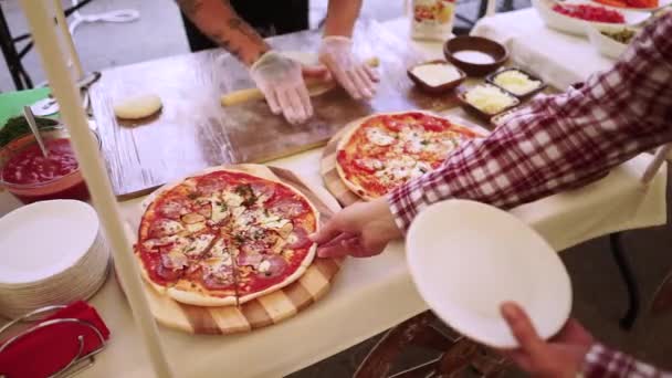 Mannen tar pizza från tabellen. — Stockvideo