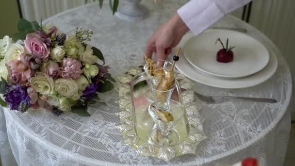 ウェイターがテーブルの上の銀の盆を置く. — ストック動画