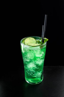 Siyah arka plan üzerine Mojito kokteyl. Güzel şeffaf buz. Yan görünüm.
