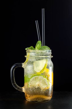 Parlak yeşil limonata kokteyl limon ve siyah arka plan üzerine nane yakılır