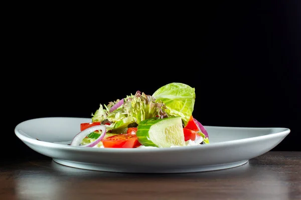 Peynir ve beyaz plaka üzerinde taze sebze salatası. — Stok fotoğraf