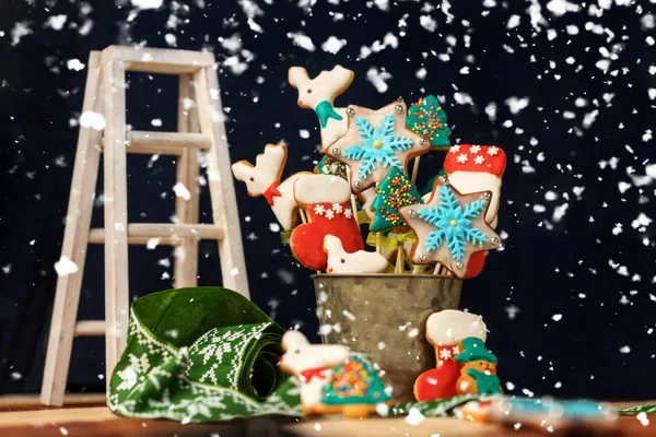Рождественский стол со сладостями, окруженный падающими снежинками . — стоковое фото