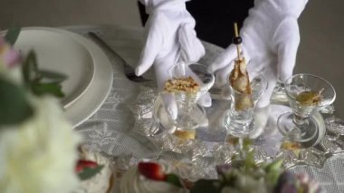 Bir gümüş tepsi üzerinde bir aperatif bir garson beyaz eldiven düzeltiyor.