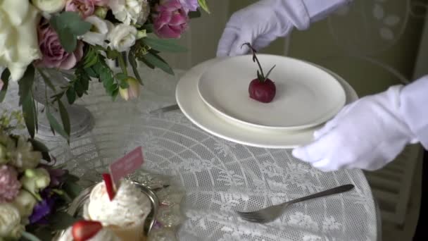 Официант кладет тарелку торта на стол . — стоковое видео