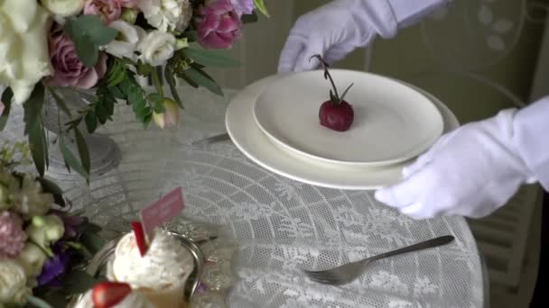 Le serveur met une assiette de gâteau sur la table . — Video