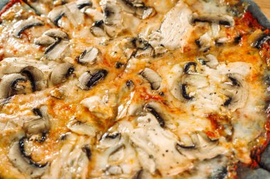 Petrol ve tavuk göğsü üzerinde siyah hamur pizza.