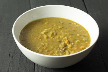 Siyah masada rustik sığır, sebze ve arpa çorbası