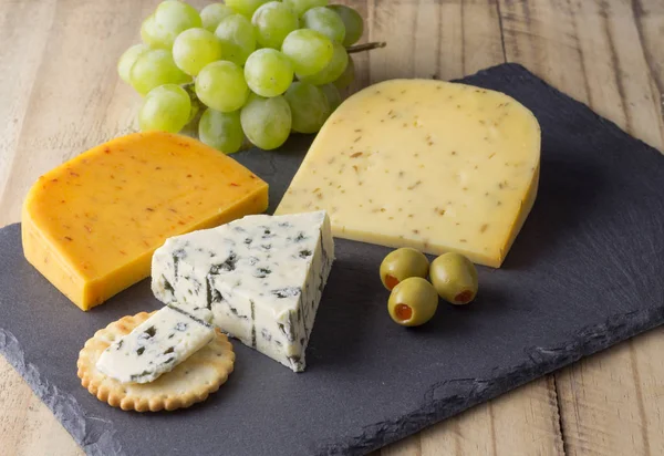 Üç peynir, yenibahar ile gouda, gouda peyniri kurula kimyon tohumu ve rokfor mavi peynir rustik ahşap arka plan üzerinde Kapat