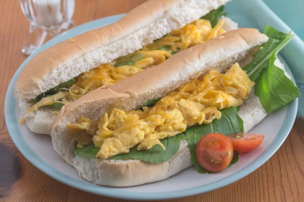 Scrambled egg sandwich - Two bread rolls with scrambled egg and rocket close up on plate