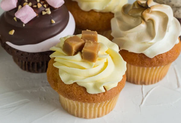 Gourmet cup cakes on textured background close up photo