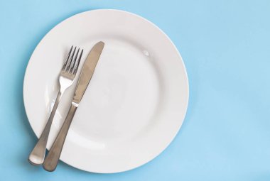 Yemek tabağı, bıçak ve çatal üzerinde mavi backgroud izole
