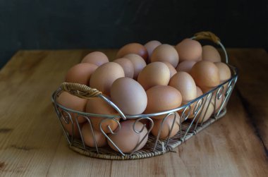 Rustik ahşap masa üzerinde bir sepet içinde Yumurta