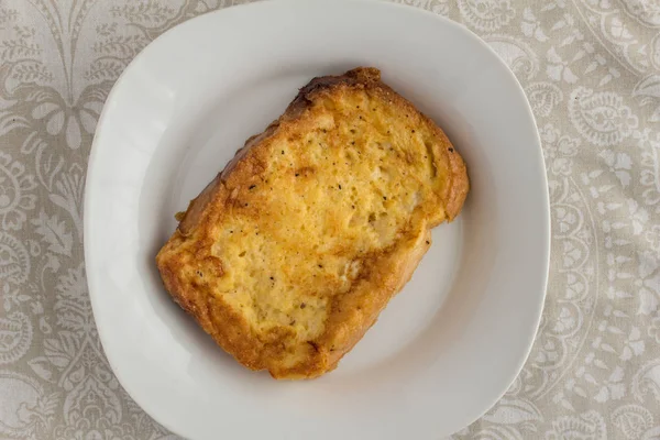 Fatia de torrada francesa saborosa em uma placa branca na mesa padronizada — Fotografia de Stock