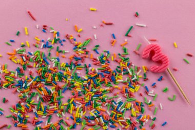 Çok renkli pasta tepesi sprinkles ve pembe üzerinde üç numaralı mum ile Doğum günü arka plan 