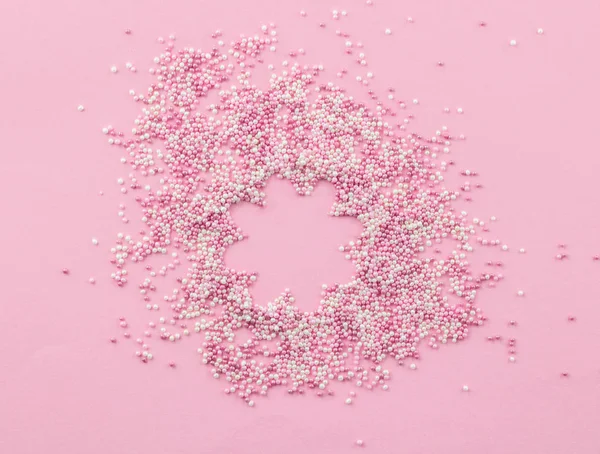 ピンクと白の食用真珠の振りかけるピンクの背景に - ケーキトッピング振りかける — ストック写真