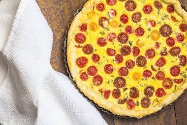 Ahşap masada çanak havlu ile pişirme konserve kiraz domates quiche - domates tart görüntü
