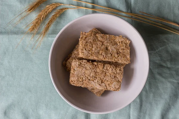 Barras de cereales en el tazón de desayuno con espigas de trigo al lado — Foto de Stock