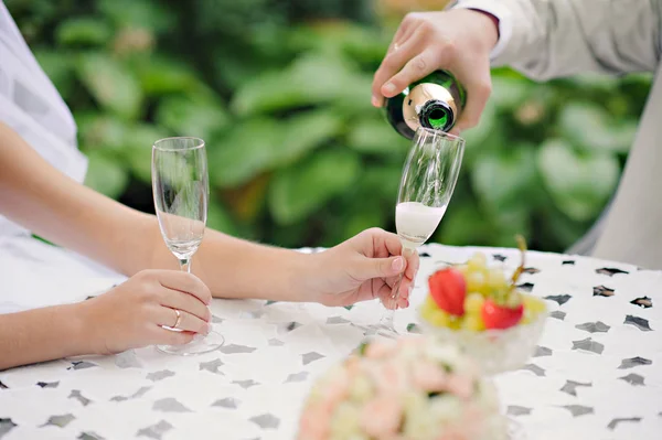 Wedding Couple Champagne Toast.Toast. Groom pouring champagne in the wedding glasses. Horizontal.