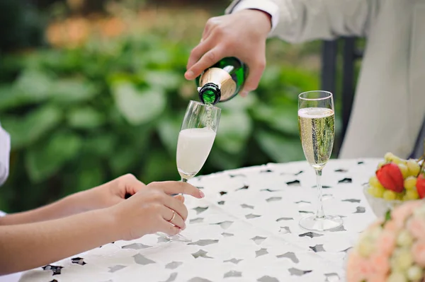 Wedding Couple Champagne Toast.Toast. Groom pouring champagne in the wedding glasses. Horizontal.