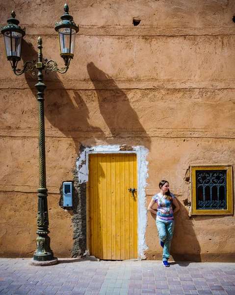 Menina em frente a um portão em Marrakech, Marrocos — Fotografia de Stock