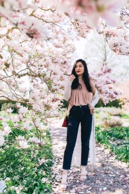 Fotoğraf oturumu güzel bir genç kızın çiçek açan Manolya, kaktüs ve diğer bitki örtüsü.