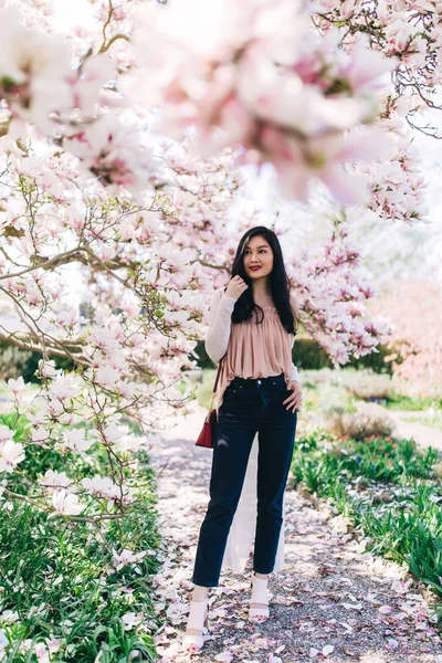 Photo Session of a beautiful young girl in blooming magnolia, cactus and other vegetation.