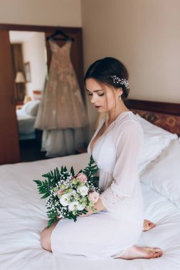 Bir gelin beyaz elbiseli güzel düğün buket tutuyor.