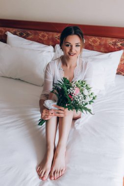 Bir gelin beyaz elbiseli güzel düğün buket tutuyor.