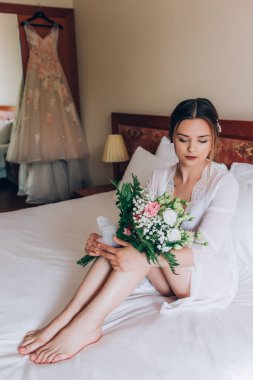 Bir gelin beyaz elbiseli güzel düğün buket tutuyor.