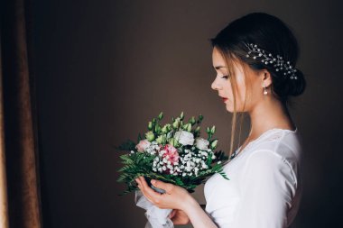 Bir gelin beyaz elbiseli güzel düğün buket tutuyor.