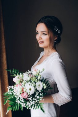 Bir gelin beyaz elbiseli güzel düğün buket tutuyor.