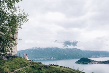 Yeni evliler doğada yürüyüş. Damat ve gelin kilisenin arka planı.