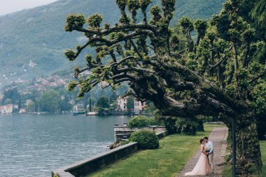 Yeni evliler doğada yürüyüş. Damat ve gelin dolgu, denizin kenarında park boyunca yürümek.