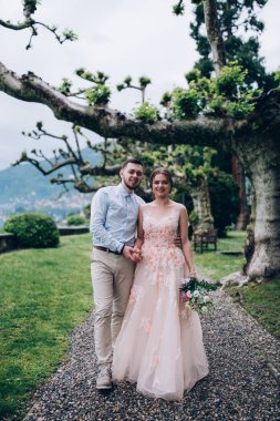 Yeni evliler doğada yürüyüş. Damat ve gelin dolgu, denizin kenarında park boyunca yürümek.