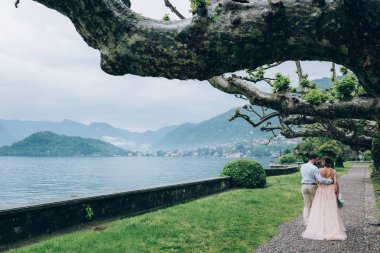 Yeni evliler doğada yürüyüş. Damat ve gelin dolgu, denizin kenarında park boyunca yürümek.