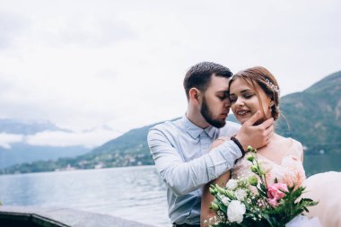 Yeni evliler doğada yürüyüş. Damat ve gelin dolgu, denizin kenarında park boyunca yürümek.