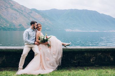 Yeni evliler doğada yürüyüş. Damat ve gelin dolgu, denizin kenarında park boyunca yürümek.