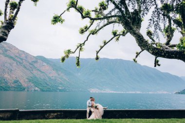 Yeni evliler doğada yürüyüş. Damat ve gelin dolgu, denizin kenarında park boyunca yürümek.