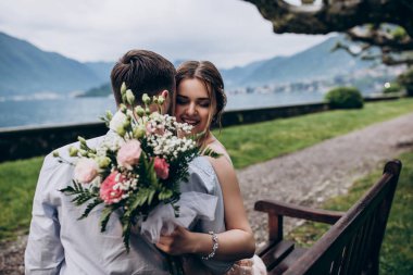 Yeni evliler doğada yürüyüş. Damat ve gelin dolgu, denizin kenarında park boyunca yürümek.