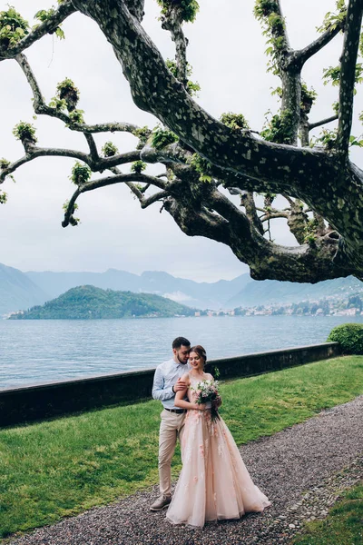 Yeni evliler doğada yürüyüş. Damat ve gelin dolgu, denizin kenarında park boyunca yürümek.