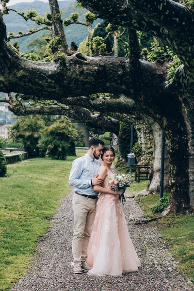Yeni evliler doğada yürüyüş. Damat ve gelin dolgu, denizin kenarında park boyunca yürümek.