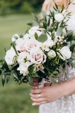 Güzel bir buket gül ile beyaz gelinlik içinde gelin.