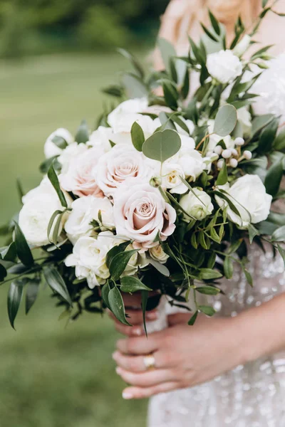 Güzel bir buket gül ile beyaz gelinlik içinde gelin.