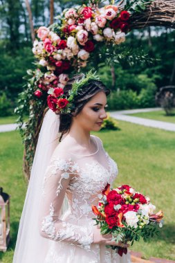 Bir gelin beyaz elbiseli güzel düğün buket tutuyor.